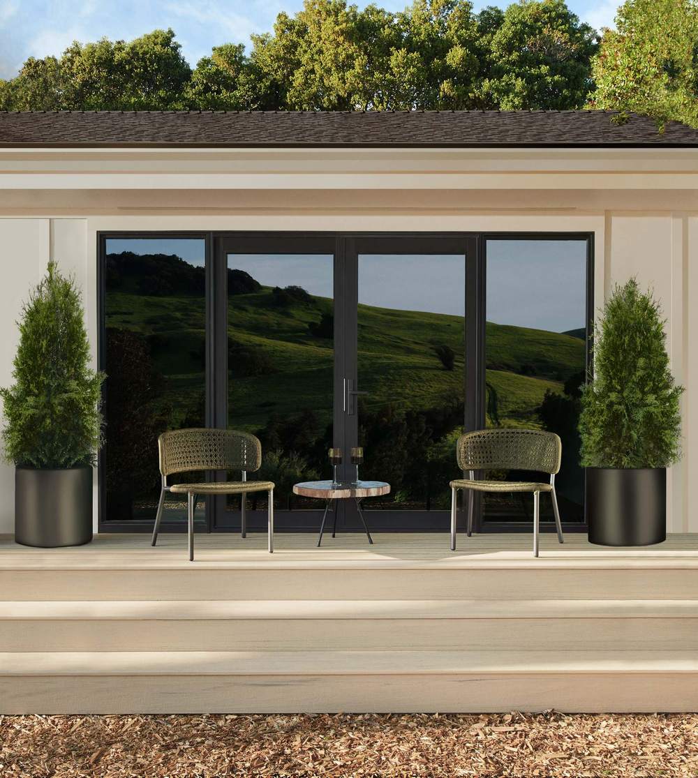 A finished composite deck with seating beside a home